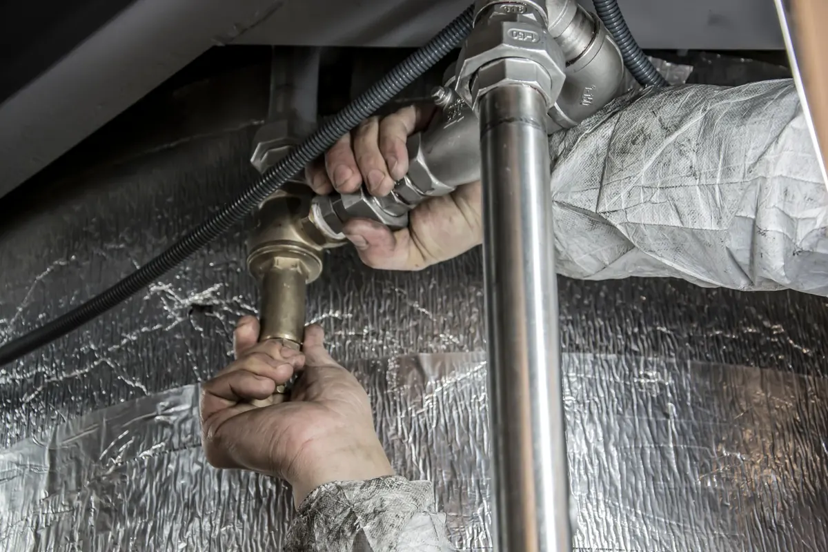 Plumber's hands fitting steel pipework by hand during a professional drain and plumbing job