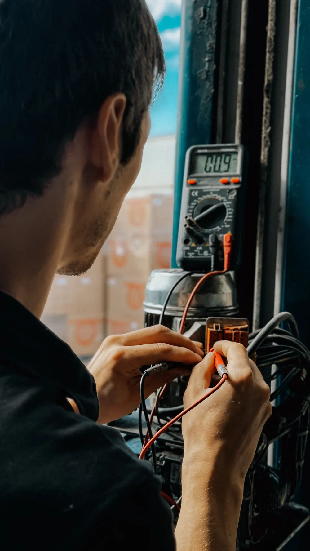 Electrician checking voltage with a digital multimeter while troubleshooting
