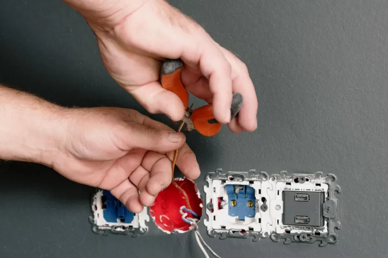 Electrician wiring new wall sockets and switches by hand