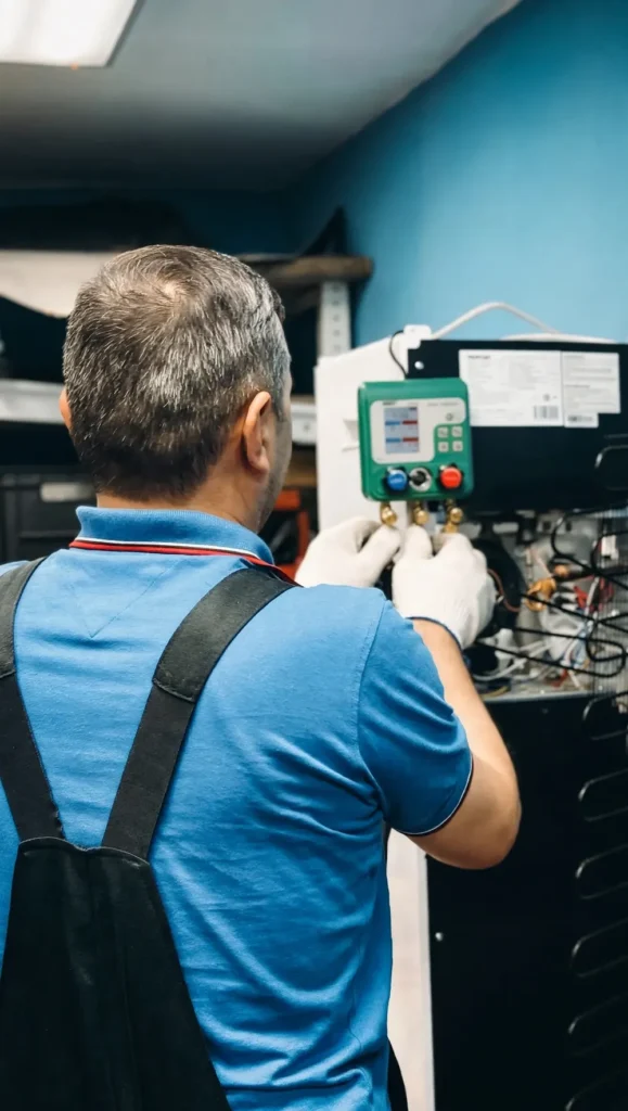 Technician testing a heating and cooling unit with a digital manifold gauge