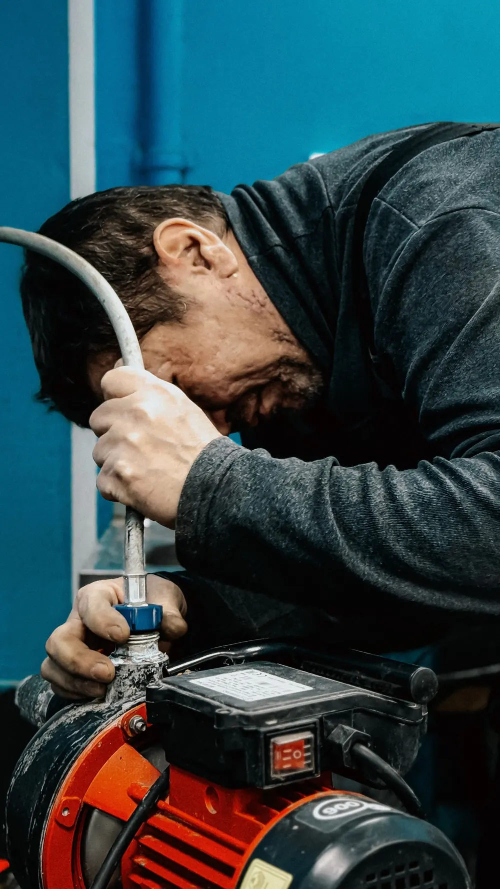 Plumber connecting pipework to a water heating unit during an installation