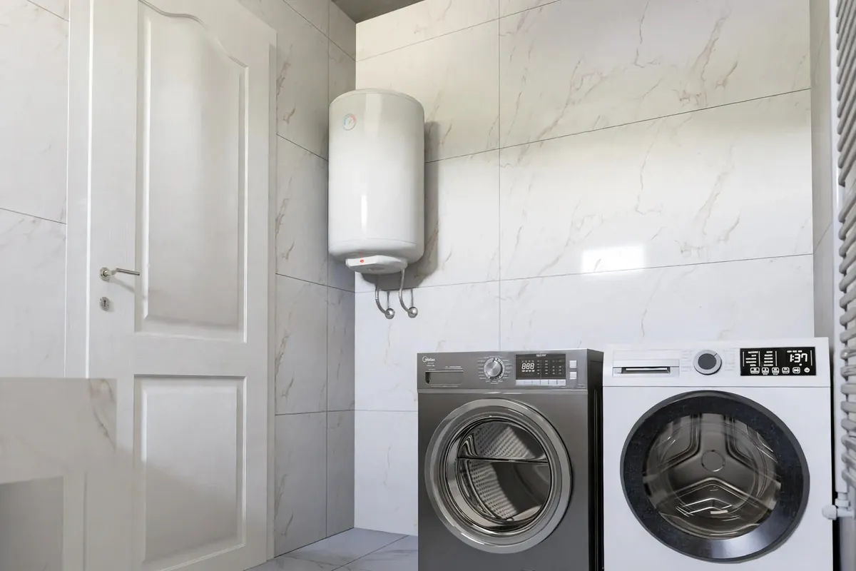 Wall-mounted electric water heater in a tiled laundry room